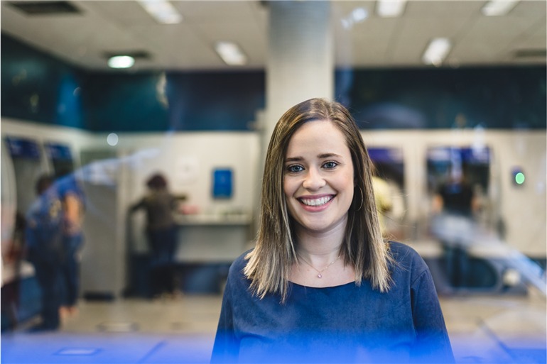 mulher sorrindo na agencia do banco caixa