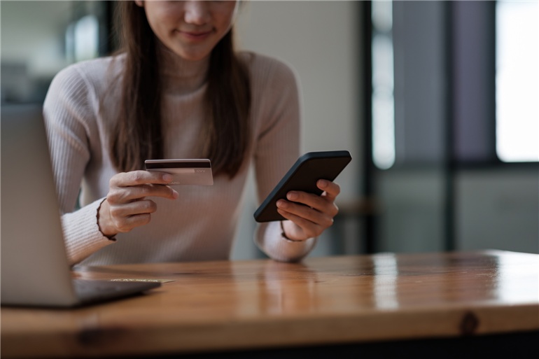 jovem segurando celular e cartao de credito