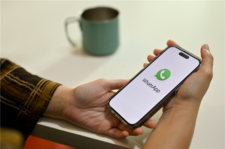 Mãos segurando celular com whatsapp aberto